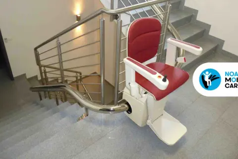 Servoscala condominio rosso e bianco, installato su una scala con corrimano in acciaio. Migliora l'accessibilità.