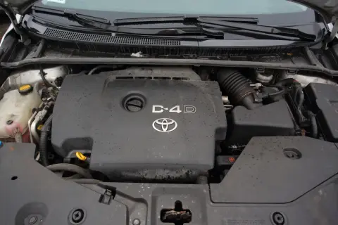 Silnik Toyota Avensis 2.0 D4D, widok z góry. Pokrywa silnika z logo Toyoty i oznaczeniem D-4D.