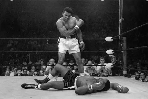 Muhammad Ali stands over a fallen opponent, embodying his famous quote to float like a butterfly and sting like a bee.