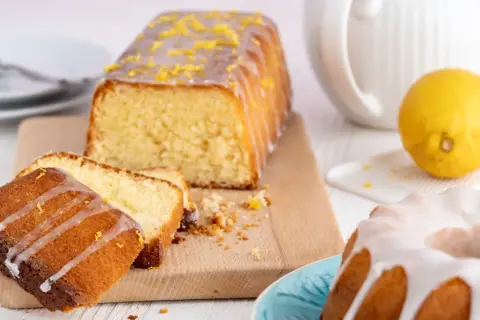 Zitronenkuchen wie bei Oma: saftiger Rührkuchen mit Zuckerguss und frischer Zitrone, daneben ein Gugelhupf.