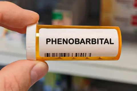 Pudełko z lekami z napisem "PHENO BARBITAL". Zawiera tabletki, które należą do grupy barbituranów.