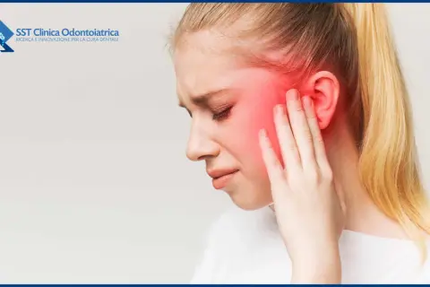 Donna con dolore alla tempia, che indica i sintomi dell'infiammazione temporo-mandibolare.