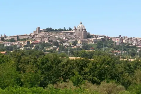 Vista panoramica di Montefiascone, con il suo imponente centro storico arroccato su una collina, che domina il paesaggio verso il lago di Bolsena.