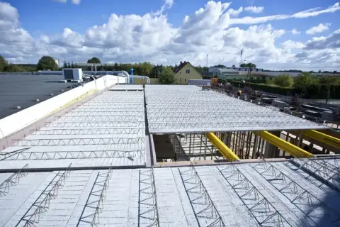 Budowa dachu z prefabrykowanych elementów, ukazująca różne rodzaje stropów w trakcie montażu.