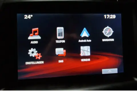 Ekran multimediów w Oplu Astrze K. Widoczne ikony: Audio, Telefon, Android Auto, Nawigacja, Ustawienia, SMS, Ruch. Temperatura 24°, godzina 17:29.