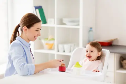 Mama karmi roczne dziecko, które z radością je. To pokazuje, ile powinno jeść roczne dziecko.