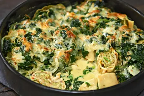 Herzhafter Maultaschen Auflauf mit Spinat und cremiger Käsesauce, goldbraun überbacken.