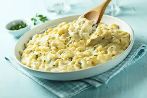 Kremowe mac and cheese z ziołami, nabierane drewnianą łyżką. Idealne na pocieszenie.