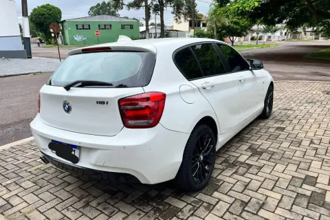 Vit vit BMW 118i står parkerad på en stenlagd uppfart. Kanske ett problem med bilen?