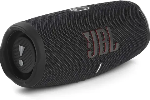 Czarny głośnik JBL z czerwonym logo. Dowiedz się, jak podłączyć słuchawki JBL z iPhone, by cieszyć się muzyką.