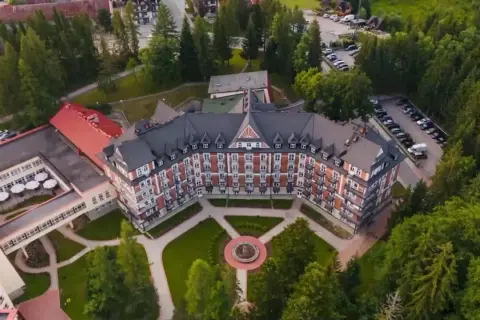 Wojskowy dom wypoczynkowy w Kościelisku, otoczony zielenią, z charakterystyczną architekturą i zadbanym ogrodem.