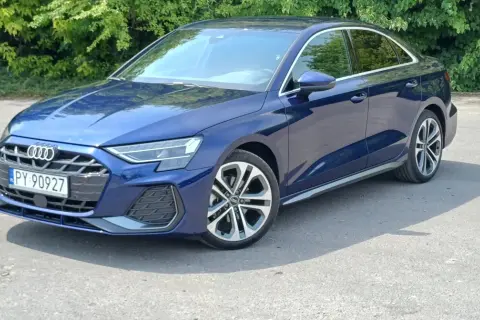 Elegancki, granatowy Audi A3 2025 sedan na tle zieleni.