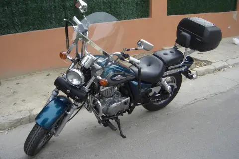 Suzuki Marauder 250 ficha técnica: moto custom azul con maleta trasera, parabrisas y guardabarros.