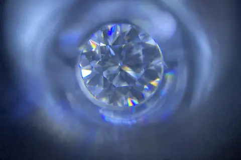 Błyszczący moissanit, co to jest? Kamień o tęczowych refleksach, przypominający diament, widziany z bliska.