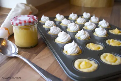 Kleine Törtchen mit Baiserhauben und einer Füllung aus Lemon Curd, bereit für köstliche Rezepte mit Lemon Curd.