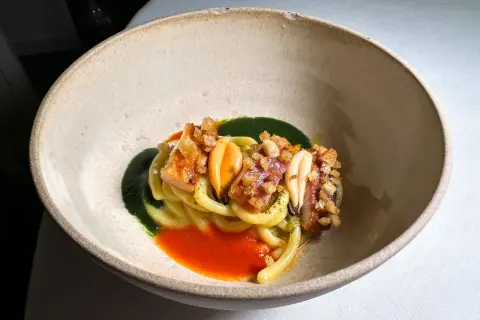 Un piatto di pasta con frutti di mare, salsa verde e rossa, croccantezza e un tocco da ciccio sultano stelle michelin.