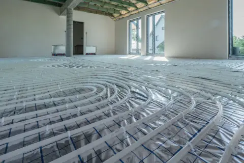 Instalacja ogrzewania podłogowego w nowym domu. Rozłożone rury zapowiadają komfort i niższy koszt ogrzewania.