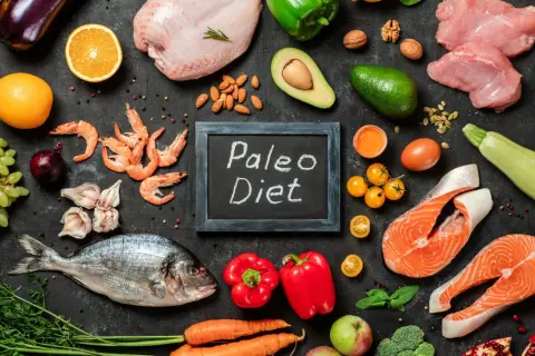 Ingredienti freschi per la dieta paleo: pesce, carne, verdura, frutta, uova e noci.