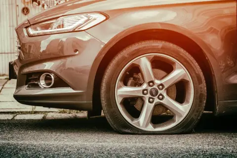 Pneu à plat sur une Ford. L'inconvénient d'une bombe anti-crevaison est qu'elle ne peut pas réparer une crevaison aussi grave.