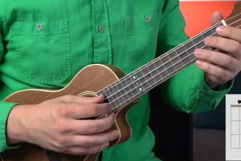 Ręce trzymają ukulele, pokazując akord. Idealne do nauki gry na ukulele dla dzieci.