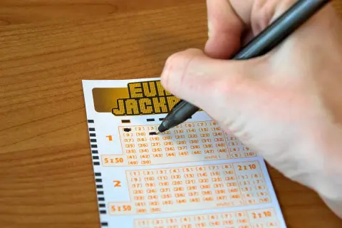 Ręka zaznacza liczby na kuponie Eurojackpot. Zastanawiasz się, dlaczego w Polsce nie można grać w Eurojackpot anonimowo przez pełnomocnika?
