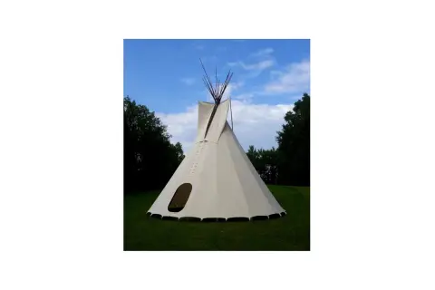 Gotowe tipi ze stabilizatorem, gotowe do rozłożenia na trawie, pod błękitnym niebem.