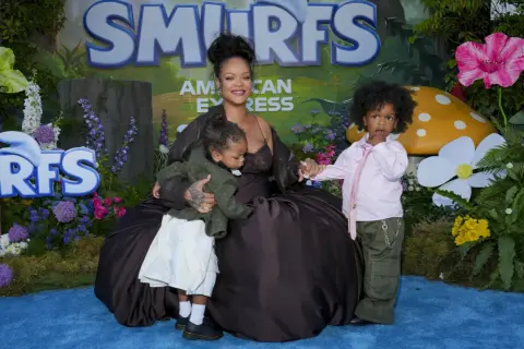 Rihanna z dziećmi na tle Smerfów. Mama tuli jedno dziecko, drugie stoi obok.