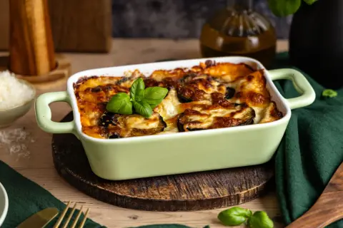 Herzhafte Auberginen Lasagne, goldbraun überbacken mit Käse und garniert mit frischem Basilikum. Ein Genuss für alle Sinne.