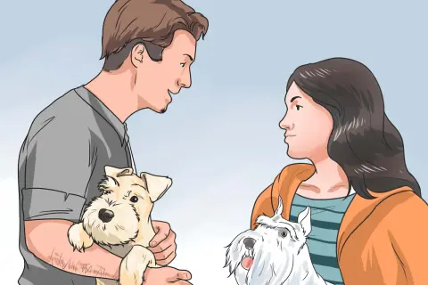 Hombre y mujer interactuando con dos perros. El hombre sostiene un perro beige, la mujer mira a un perro blanco. Aprende como ganarse la confianza de un perro.