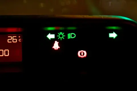 Na desce rozdzielczej świecą się zielone kontrolki: kierunkowskaz lewy, światła mijania, światła drogowe (high beam assist) i kierunkowskaz prawy. Czerwone kontrolki: pasy i hamulec.