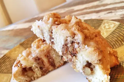 Zwei saftige Nussschnecken mit Zuckerguss und Nüssen, bereit zum Genießen. Ein tolles Nussschnecken Rezept!