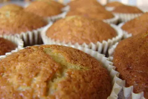 En närbild på flera gyllene bananmuffins utan socker i sina pappersformar. De ser saftiga och hembakade ut.