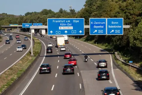 Autostrada w Niemczech, ruch samochodowy. Znaki drogowe wskazują kierunki: Frankfurt, Olpe, Kolonia, Bonn. Uważaj na mandaty w niemczech!