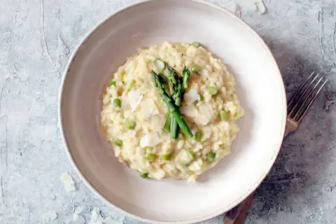 Cremiges Spargel-Erbsen-Risotto, garniert mit frischem Spargel und Parmesan. Ein köstliches Beispiel, was ist risotto.