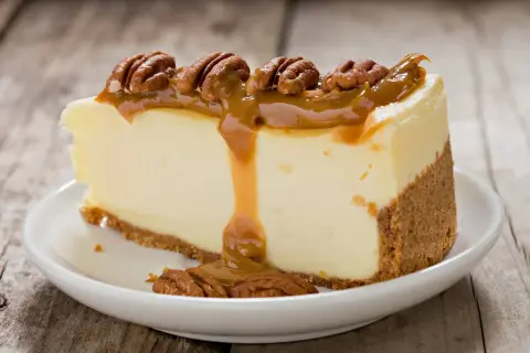 Deliciosa tarta de queso con dulce de leche y nueces pecanas, un postre irresistible.