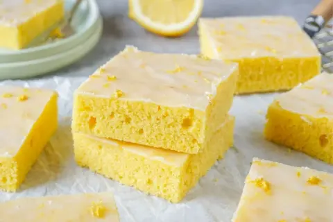 Saftiger zitronenkuchen blech, mit Zuckerguss und Zitronenschale bestreut, bereit zum Genießen.