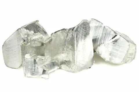 Pezzi grezzi di metallo argenteo, con striature evidenti, che ricordano un rivestimento in stagno grezzo.