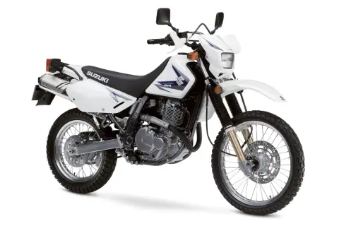 Biały motocykl Suzuki DR650SE, idealny na lekkie enduro turystyczne, gotowy na przygodę.