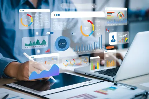 Big data scientist analizujący wykresy i dane na ekranach.