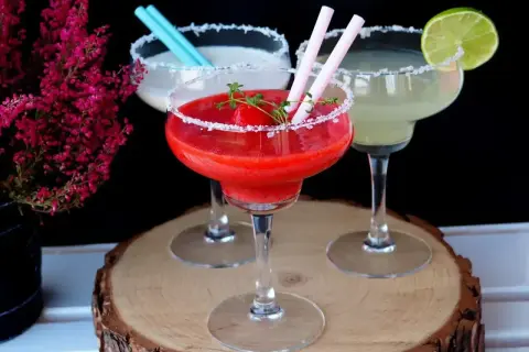 Trzy drinki margarita: jedna truskawkowa, jedna biała i jedna zielona.