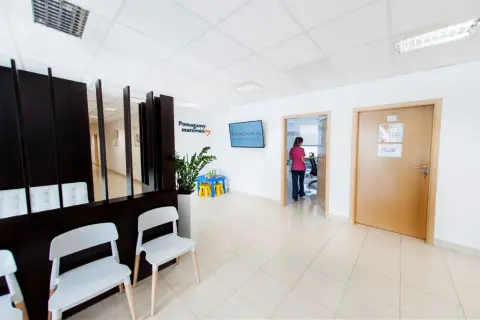 Najlepsze kliniki leczenia niepłodności w Krakowie - ranking placówek. Poczekalnia z wygodnymi fotelami i tablicą informacyjną.