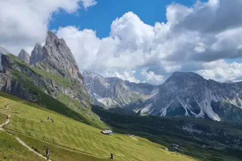 Sentiero panoramico tra prati verdi e vette maestose, ideale per escursioni in Alto Adige.