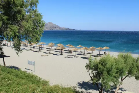 Piękna pogoda w Grecji w maju: piaszczysta plaża, turkusowe morze i palmy. Idealne miejsce na relaks.