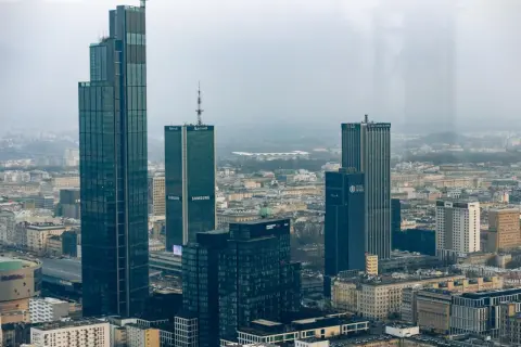 Warszawski krajobraz zdominowany przez wieżowce, w tym najwyższy budynek w Polsce. Widać też budynki z logotypami Samsung i Marriott.