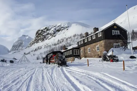 Vinterlandskap vid Nikkaluokta Kebnekaise med snöskotrar och fjällstation.