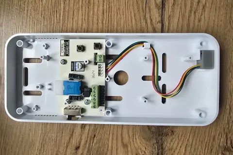 Wnętrze domofonu Cyfral Smart 5P z widoczną płytką drukowaną i przewodami.
