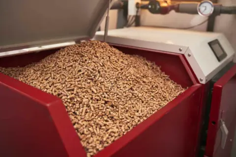 Ein großer Vorrat an Holzpellets in einem roten Behälter, bereit für die Pelletheizung.
