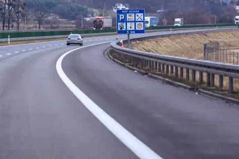 Autostrada z pasem awaryjnym. Znak informuje o MOP MSZANA, toalecie, busach i odległości 5 km.