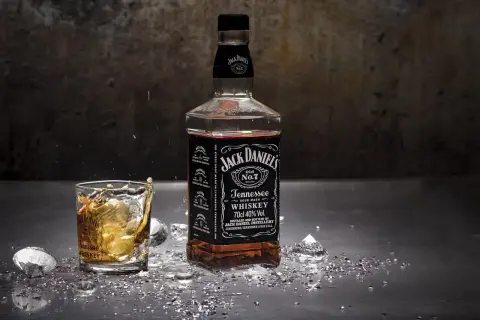 Butelka Jack Daniel's i szklanka z whiskey, w której widać rozprysk. Zastanawiasz się, jak smakuje bourbon?