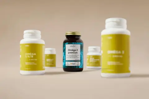 Plusieurs flacons d'oméga-3, dont un flacon brun "Oméga-3 premium" issu de poissons sauvages, suggérant une cure d'huile de poisson oméga 3.